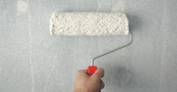 Paint roller painting a wall.