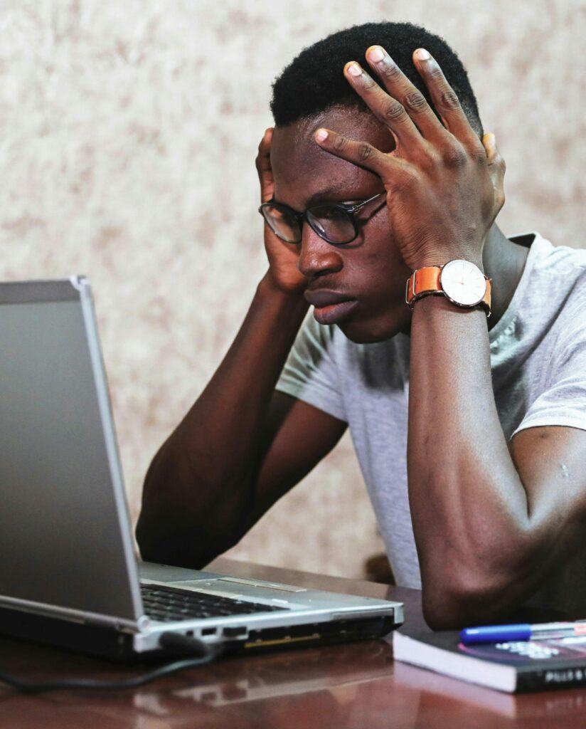 Frustrated man staring at a laptop.