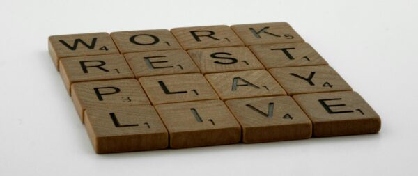 Scrabble pieces spelling "Work, rest, play, live."