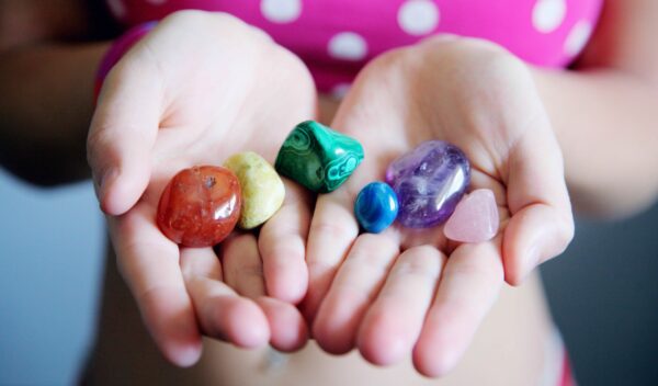 Hands holding different colored stones